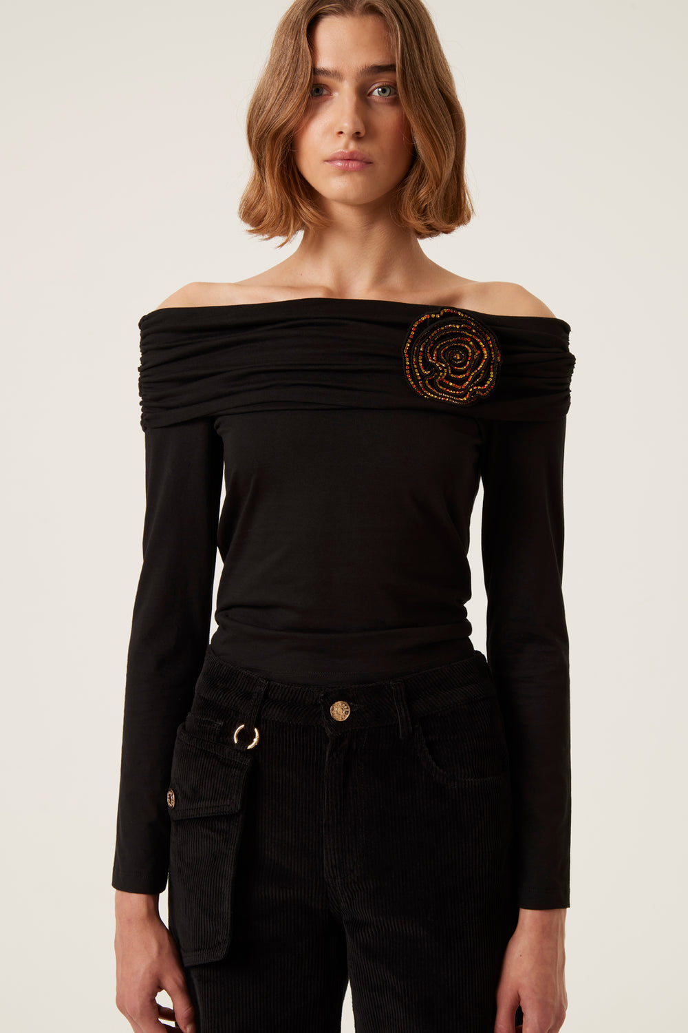 Black top with jewel brooch